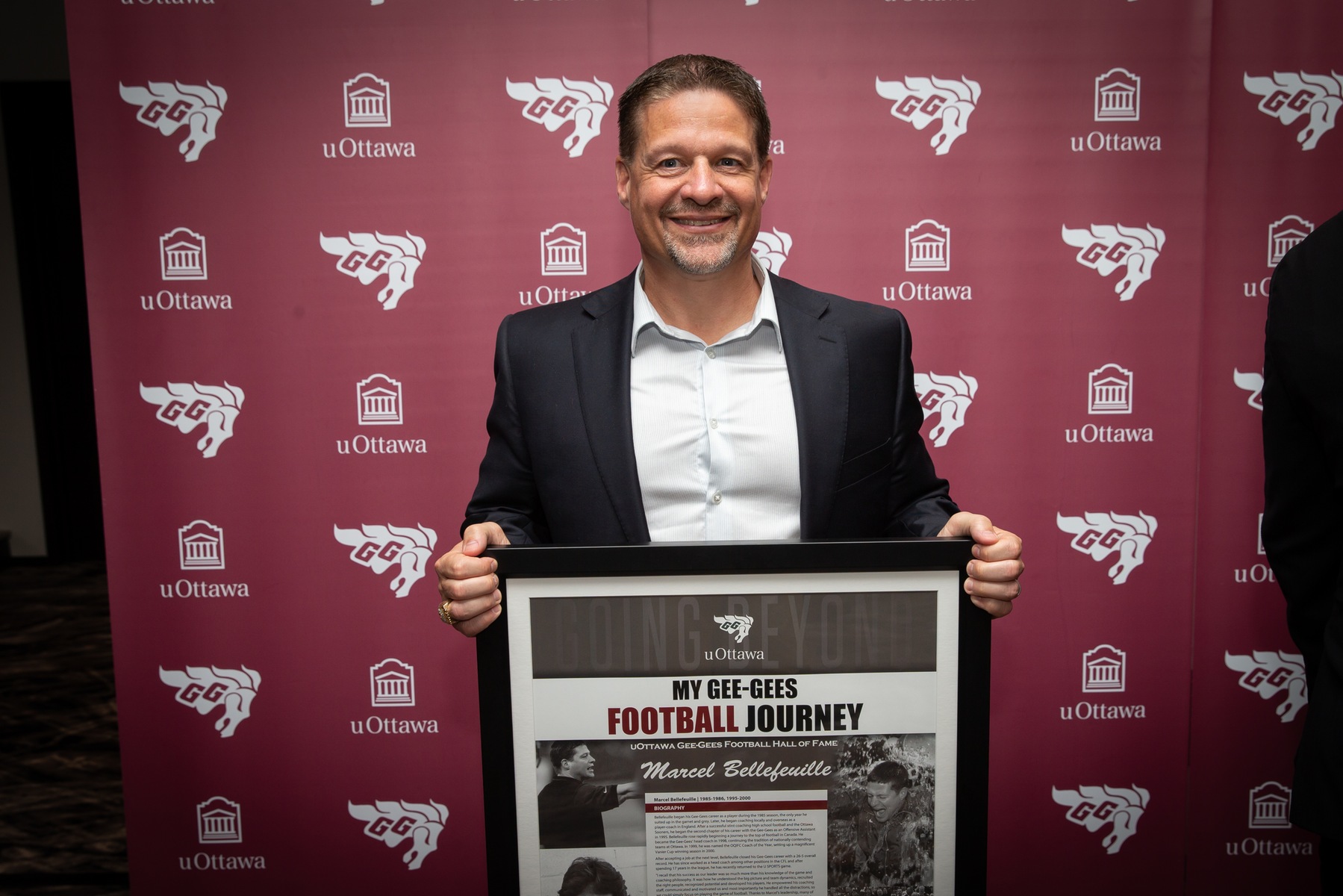 Marcel Bellefeuille holds a plaque.
