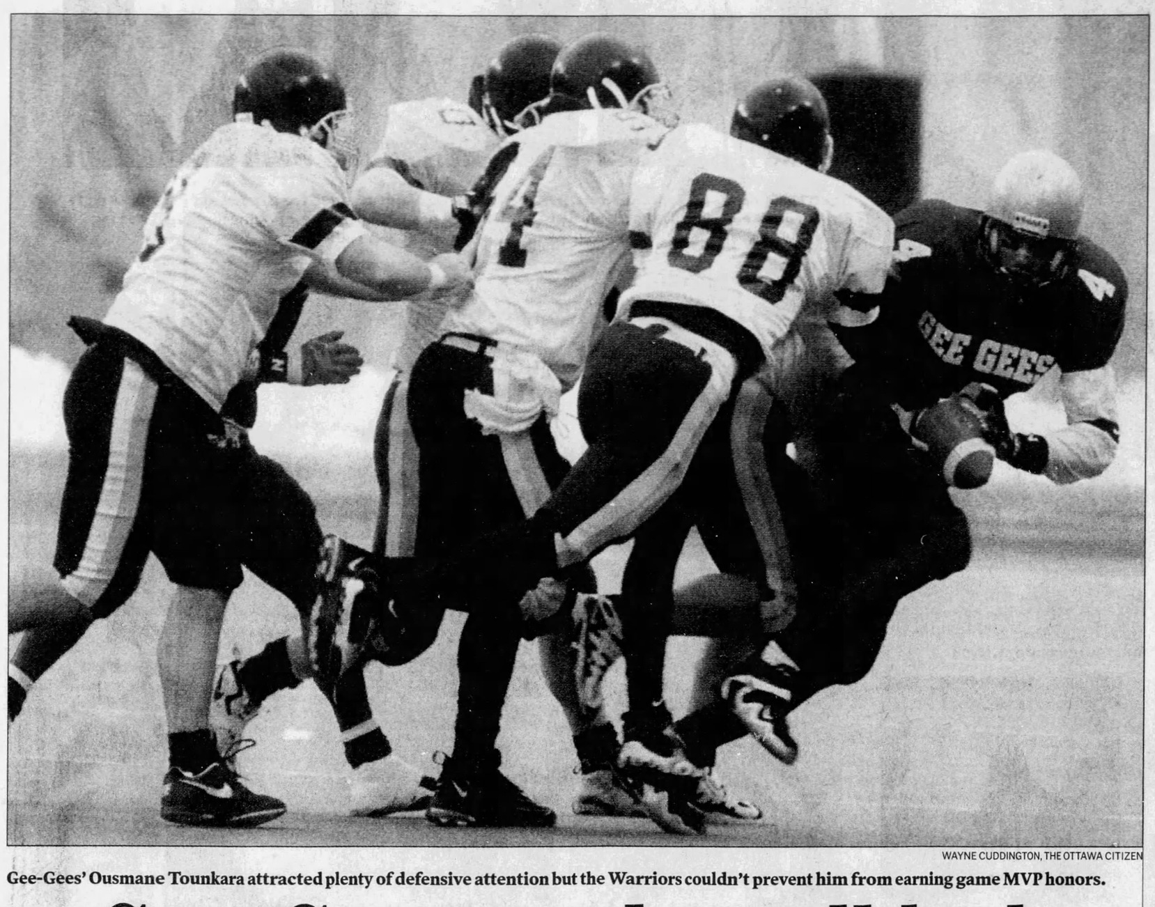 Black and white newspaper clipping with the caption: Gee-Gees' Ousmane Tounkara attracted plenty of defensive attention but the Warriors couldn't prevent him from earning game MVP honours. Wayne Cuddington, The Ottawa Citizen.