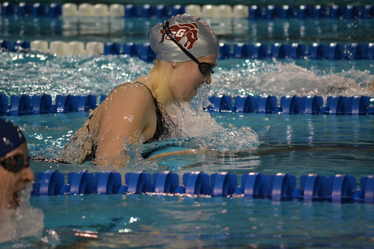 Eryn Weldon swims the breaststroke, racing ahead of another swimmer who is in the lower left corner.