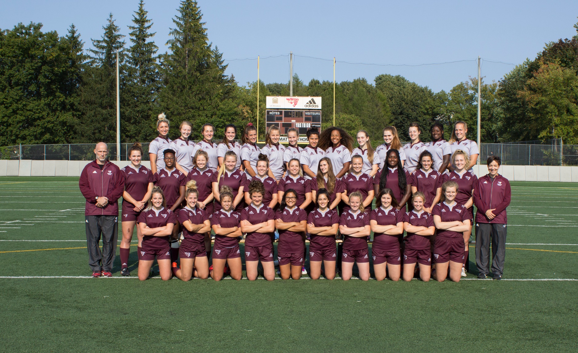 Gee-Gees women's rugby players and staff in a team photo taken on Matt Anthony Field.