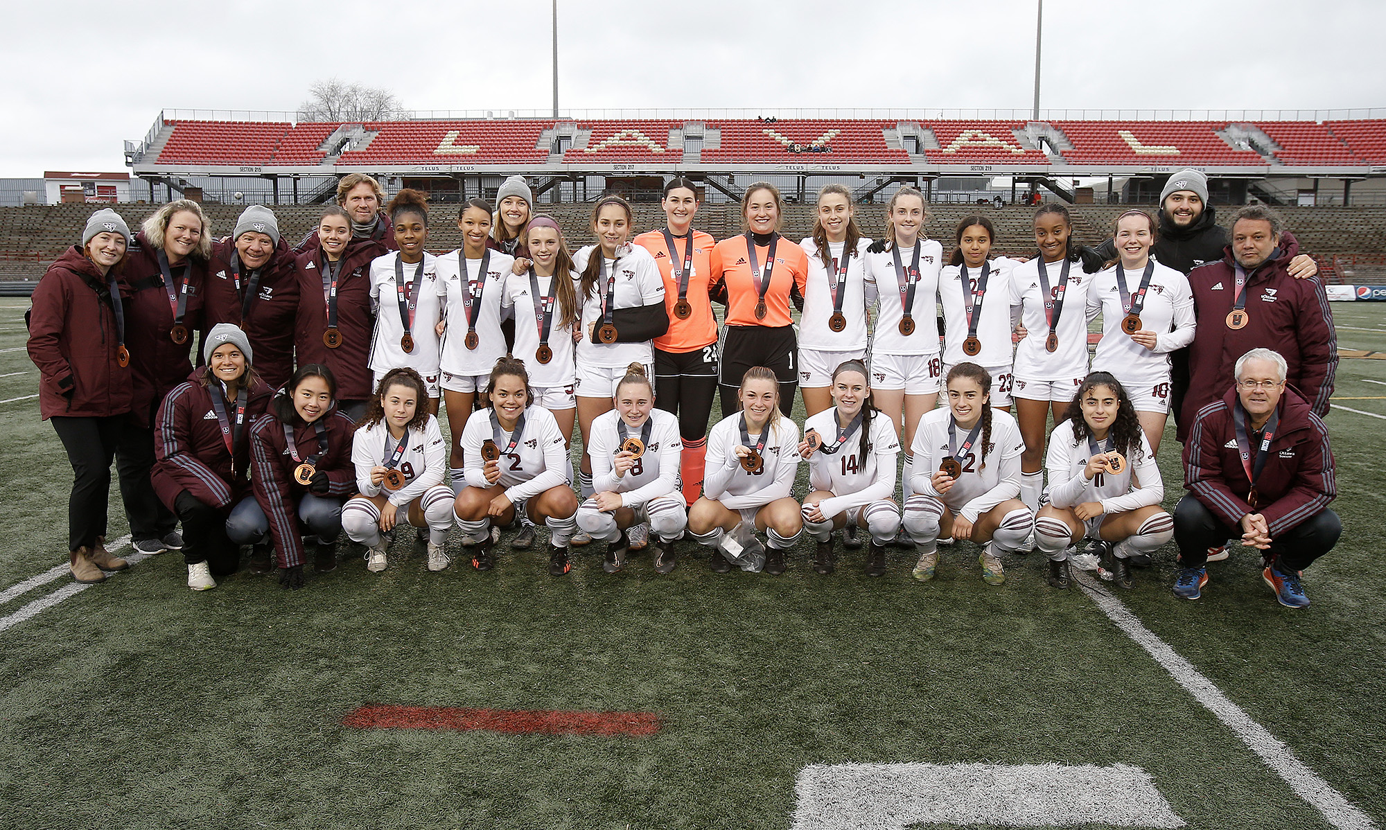 Gee-Gees women's soccer team players and coaches with their bronze medals from the National Championship at the University of Laval.