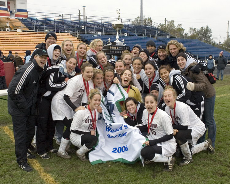 Team photo with championship banner at Queen's Richardson Stadium