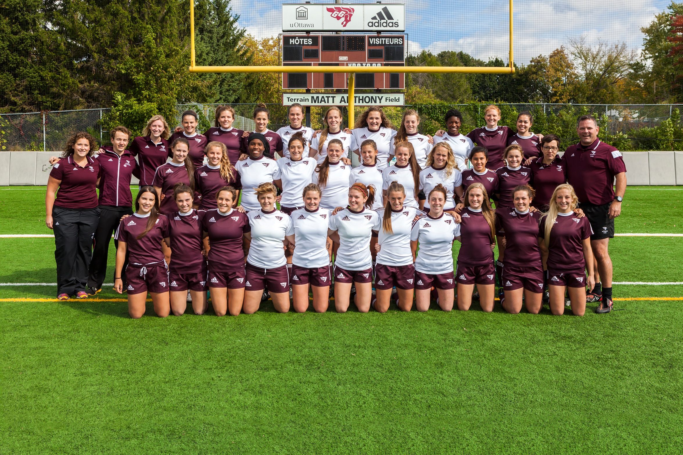 Team photo of players and staff for 2014 Gee-Gees women's rugby, taken on the field at Matt Anthony Field.